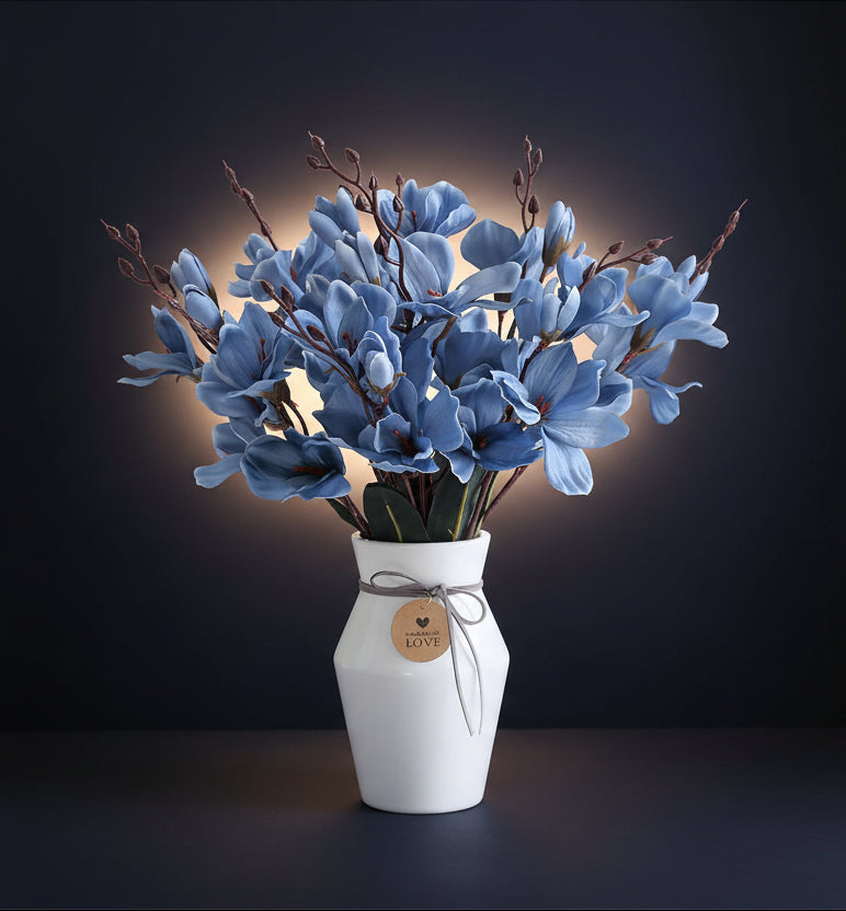 Bouquet of blue flowers in a white vase on a white background