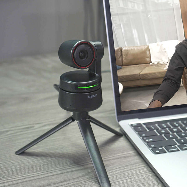 OBSBOT Tiny 4K AI PTZ Webcam on a tripod connected to a laptop for high-quality video conferencing and professional presentations